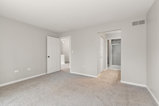 unfurnished bedroom featuring a spacious closet and light carpet