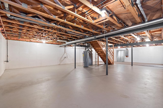 basement featuring electric panel and water heater