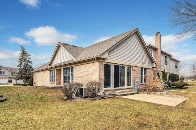 rear view of property featuring a lawn