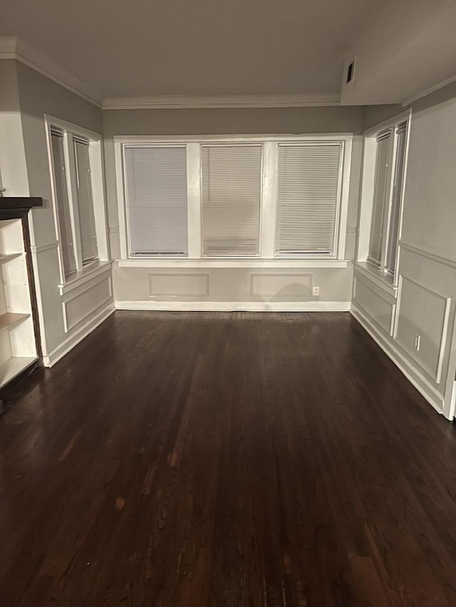 unfurnished living room with ornamental molding and dark hardwood / wood-style floors