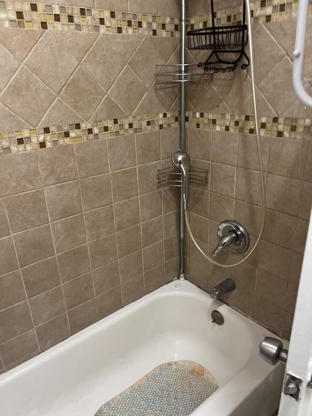 bathroom featuring tiled shower / bath