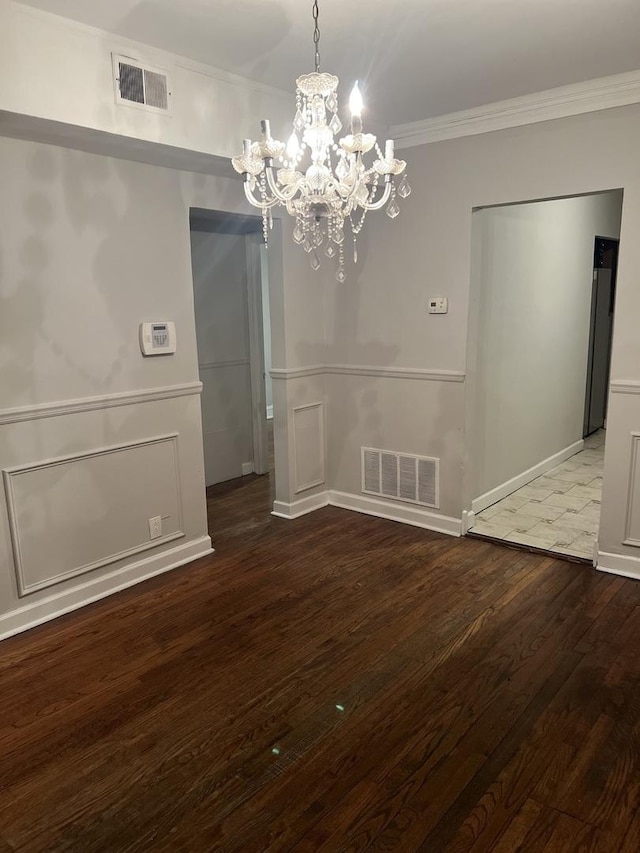 unfurnished dining area with ornamental molding, a chandelier, and hardwood / wood-style floors