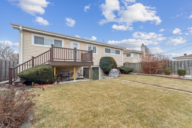 back of house featuring a wooden deck and a yard