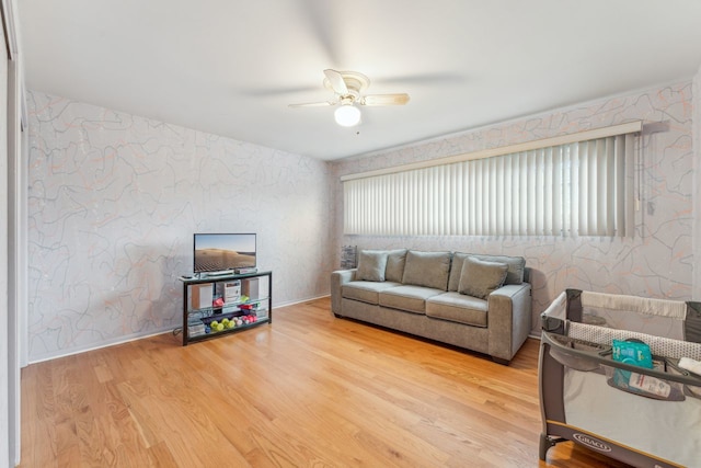 living room featuring wood-type flooring and ceiling fan