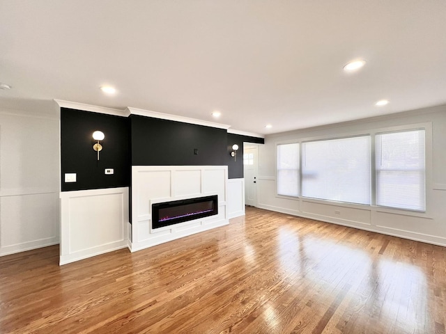 unfurnished living room featuring ornamental molding and light hardwood / wood-style flooring