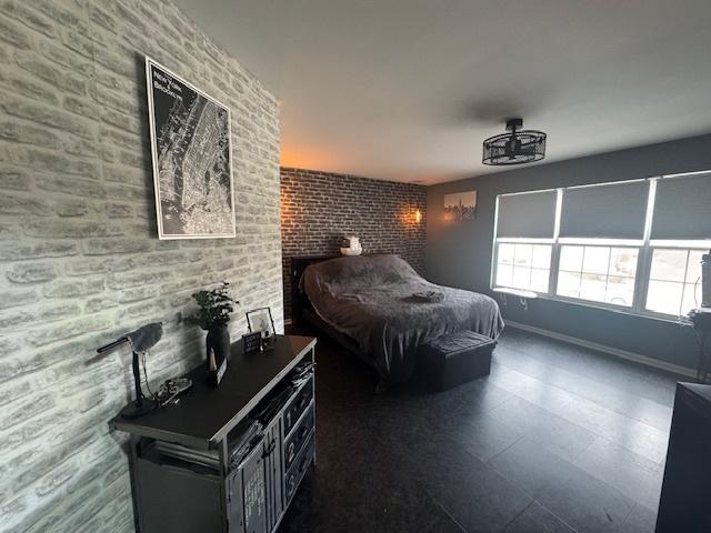 bedroom featuring brick wall