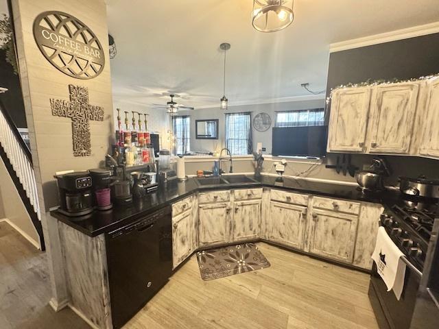 kitchen with sink, black dishwasher, light hardwood / wood-style floors, light brown cabinetry, and gas range