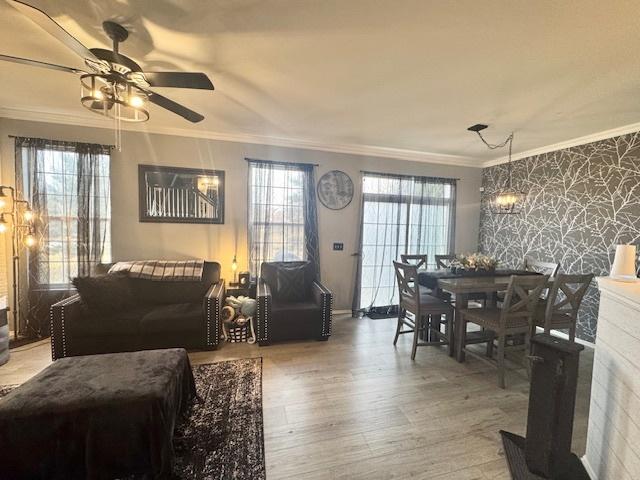 living room with hardwood / wood-style flooring, crown molding, and ceiling fan