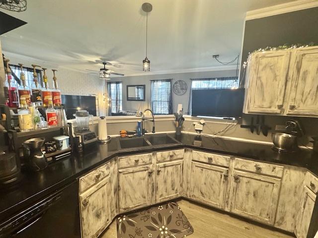 kitchen featuring ornamental molding, sink, dishwashing machine, and kitchen peninsula