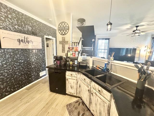 kitchen featuring sink, light hardwood / wood-style flooring, ceiling fan, black dishwasher, and decorative light fixtures