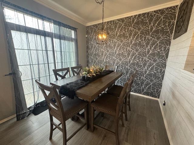 dining area featuring hardwood / wood-style flooring and ornamental molding