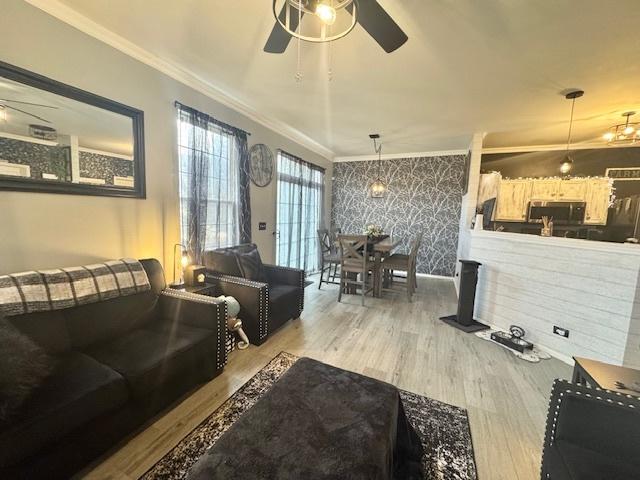 living room with crown molding, hardwood / wood-style floors, and ceiling fan