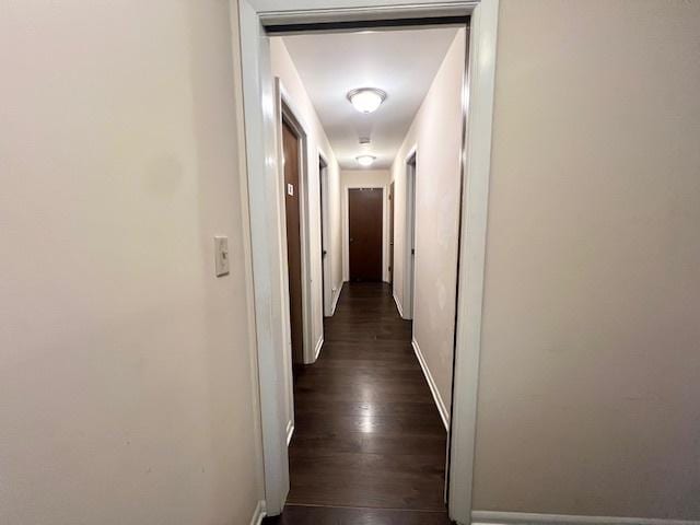 hall featuring baseboards and dark wood finished floors