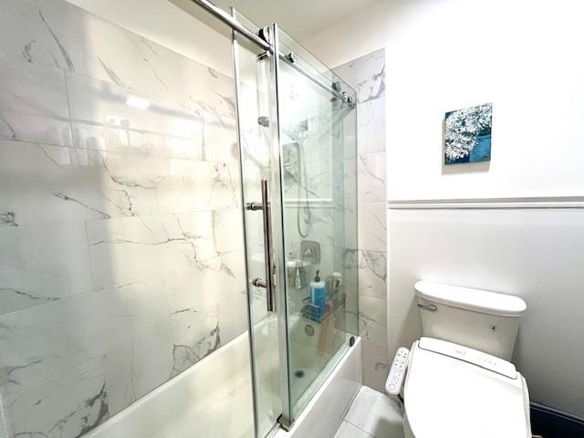 full bath featuring toilet and bath / shower combo with glass door