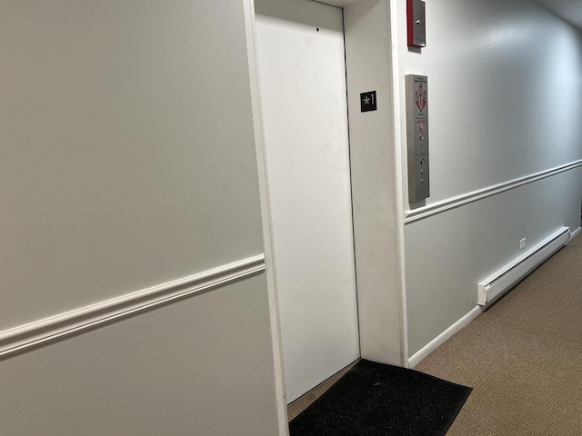 corridor featuring a baseboard heating unit and carpet flooring