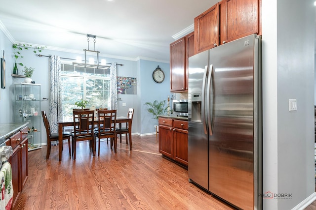 kitchen featuring hanging light fixtures, stainless steel refrigerator with ice dispenser, crown molding, and light hardwood / wood-style flooring