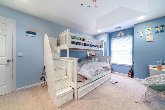 bedroom featuring light colored carpet and a tray ceiling