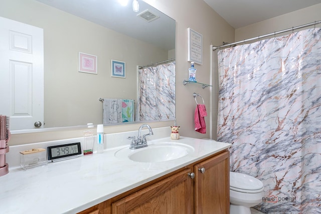 bathroom featuring vanity, toilet, and walk in shower