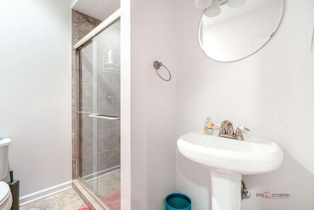 bathroom with toilet, tile patterned flooring, and a shower with door