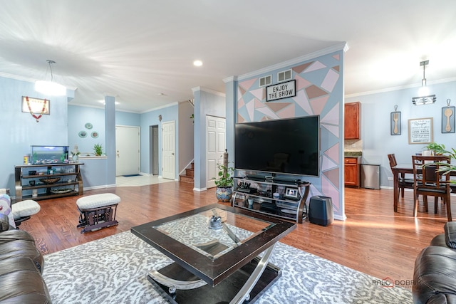 living room featuring ornamental molding and light hardwood / wood-style flooring