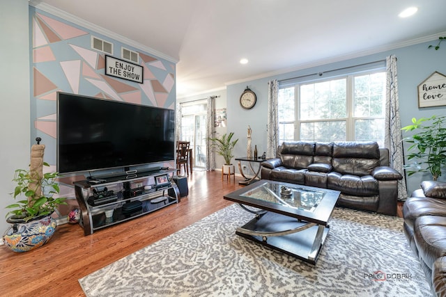 living room with hardwood / wood-style flooring, ornamental molding, and plenty of natural light