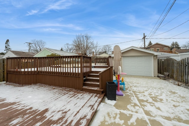 snow covered deck with a garage and an outdoor structure