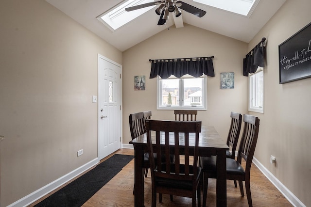 dining area with lofted ceiling with beams, wood-type flooring, and ceiling fan