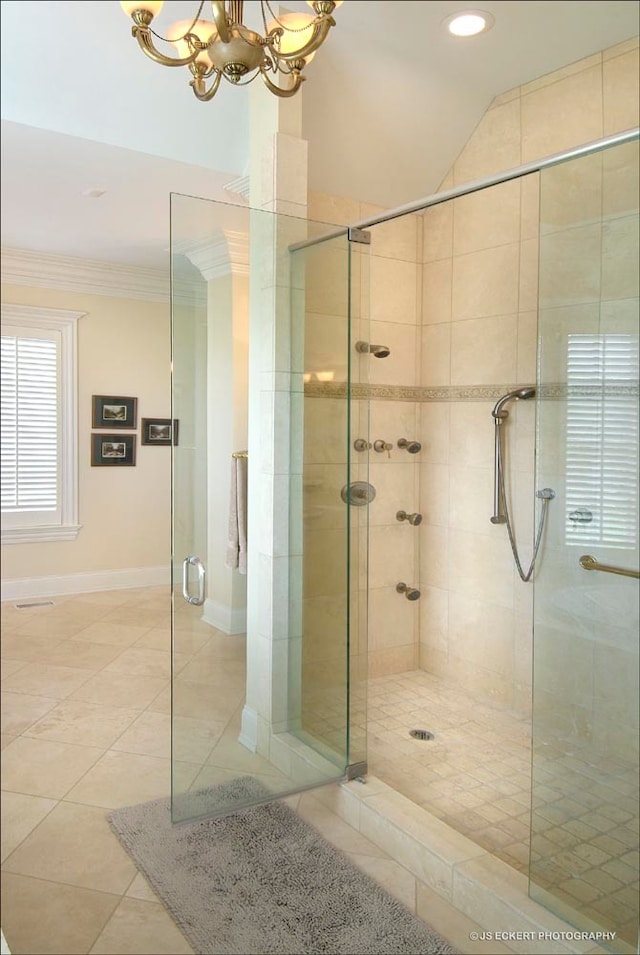 bathroom featuring tile patterned flooring, a shower with door, ornamental molding, and a chandelier