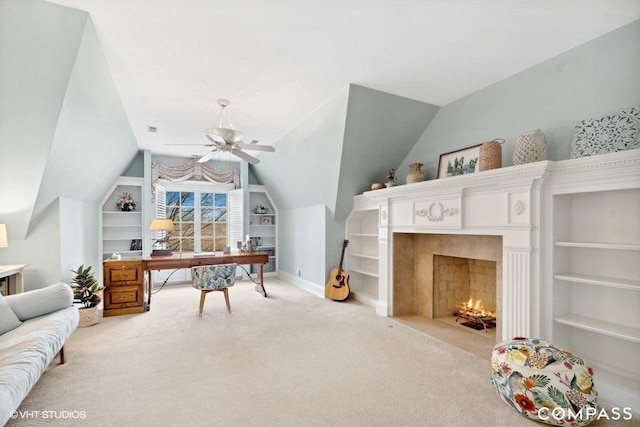 carpeted home office with lofted ceiling, built in features, and ceiling fan