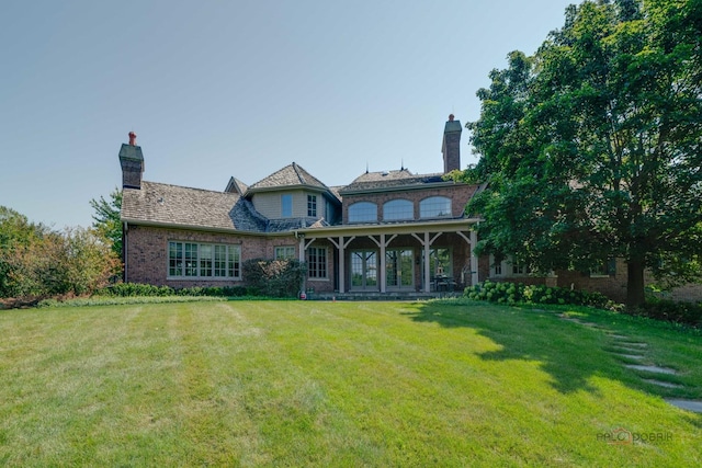 rear view of house featuring a yard