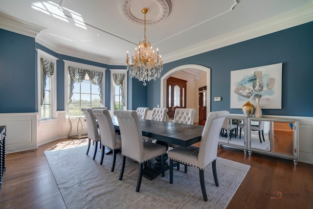 dining area with ornamental molding, dark hardwood / wood-style flooring, a tray ceiling, and a notable chandelier