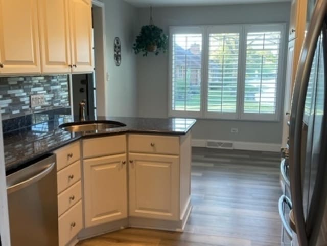 kitchen featuring sink, dishwasher, backsplash, fridge, and kitchen peninsula