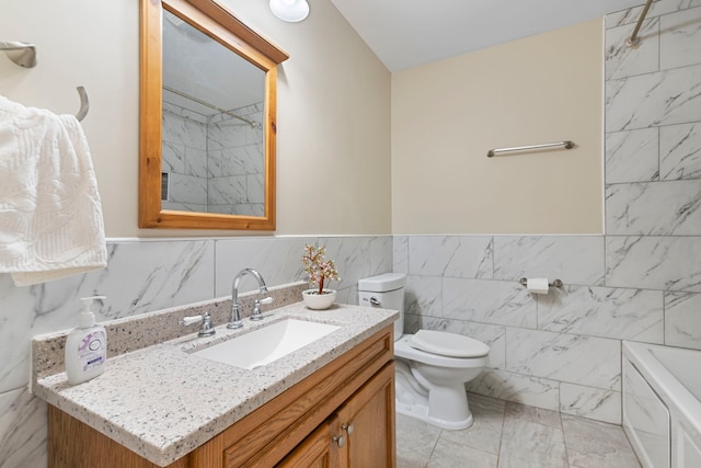 bathroom with toilet, vanity, a bath, and tile walls