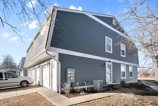 view of side of property with a garage and central AC