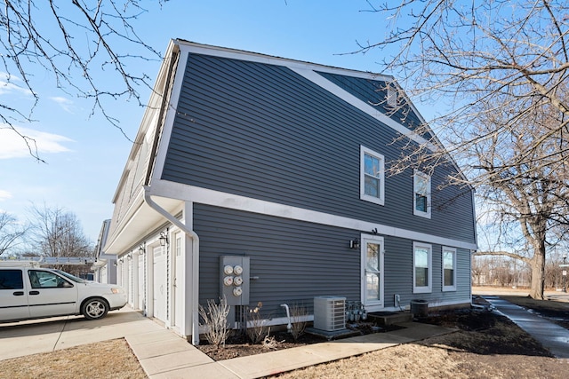 view of side of property with a garage and central air condition unit