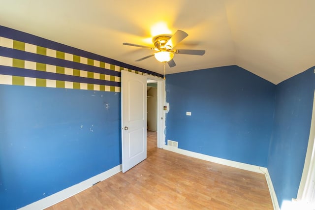 unfurnished bedroom with ceiling fan, lofted ceiling, and light hardwood / wood-style flooring