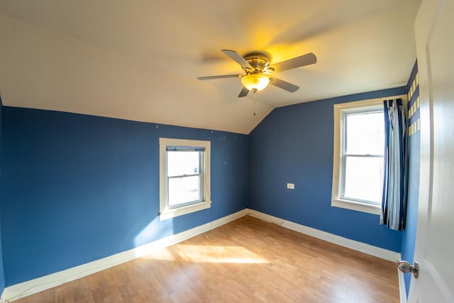 additional living space featuring a wealth of natural light, wood-type flooring, ceiling fan, and vaulted ceiling