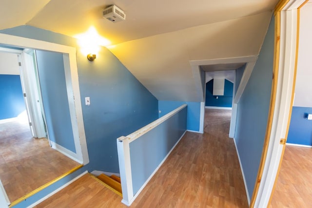 hall featuring hardwood / wood-style floors and vaulted ceiling