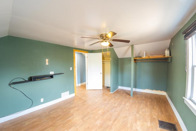 unfurnished bedroom with ceiling fan, lofted ceiling, light hardwood / wood-style floors, and multiple windows