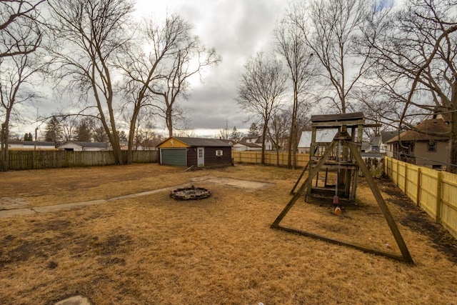 view of playground with an outdoor fire pit and an outdoor structure