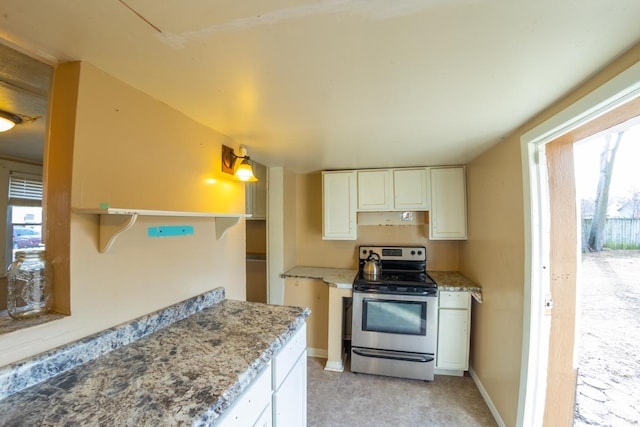 kitchen with light stone counters, stainless steel electric range, and white cabinets