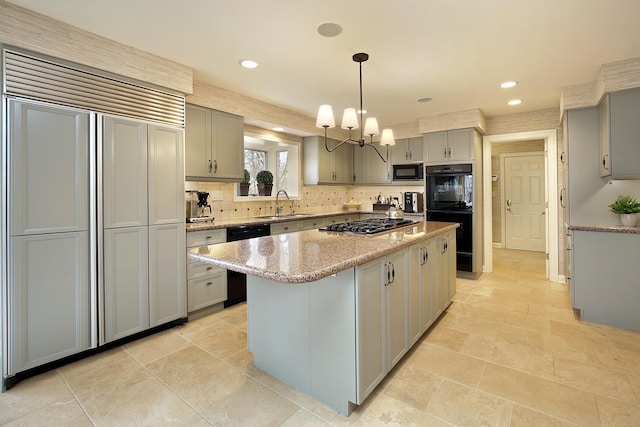 kitchen with gray cabinetry, a center island, light stone countertops, black appliances, and decorative light fixtures