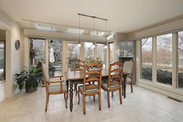 sunroom / solarium featuring track lighting