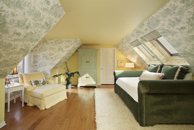 bedroom featuring hardwood / wood-style flooring and lofted ceiling with skylight