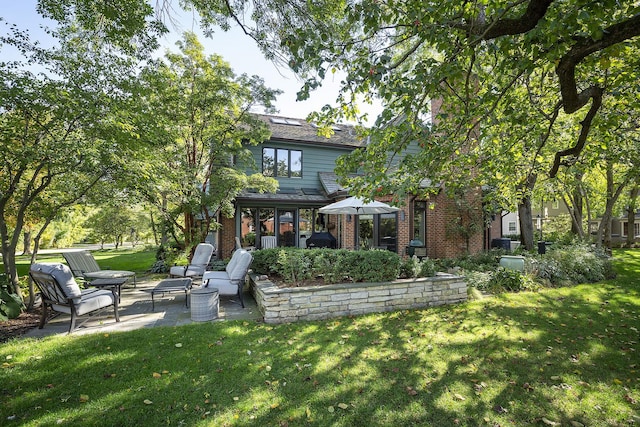 rear view of house with a yard and a patio