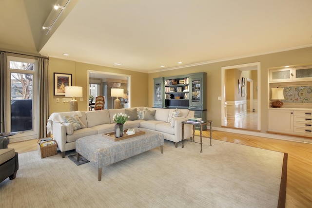 living room with ornamental molding and light wood-type flooring