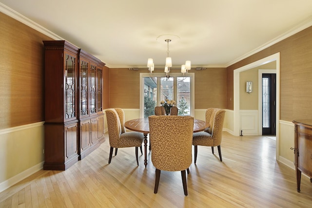 dining area featuring crown molding, a chandelier, and light wood-type flooring