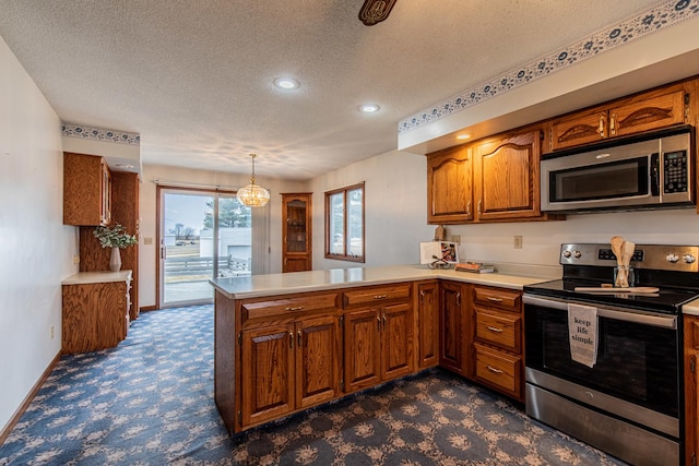 kitchen featuring appliances with stainless steel finishes, carpet floors, a textured ceiling, decorative light fixtures, and kitchen peninsula