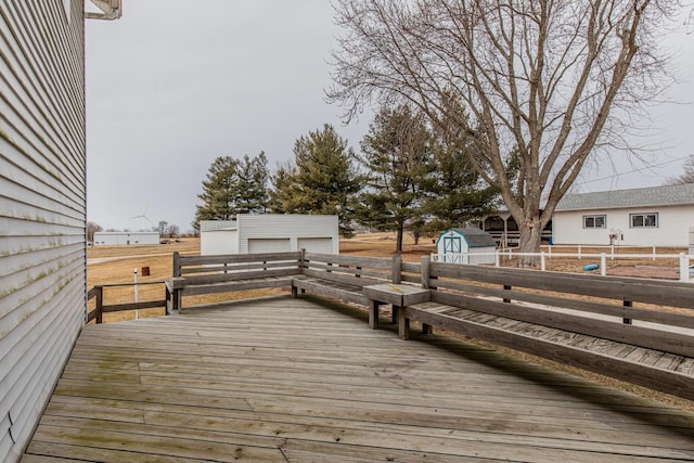 wooden terrace featuring a garage and a storage unit