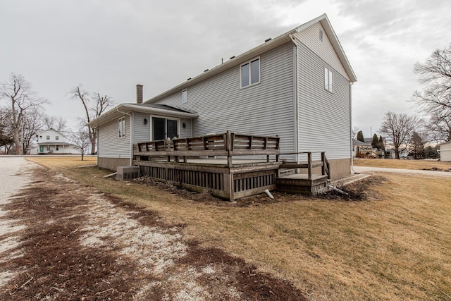 back of house featuring a wooden deck, a yard, and central AC